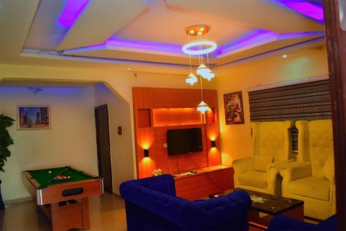 a living room with a pool table and a tv at Clint Cottage Hotel in Odo