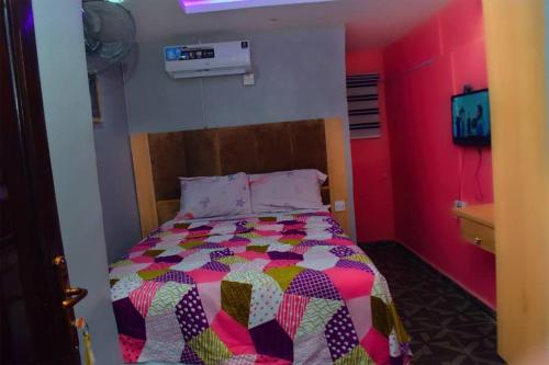 a bedroom with a bed with a colorful comforter at Clint Cottage Hotel in Odo
