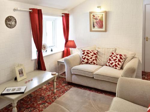 a living room with a couch and a table at Gamekeepers Apt - Cv20 in Liskeard
