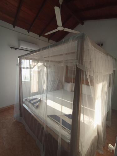 a bedroom with a canopy bed with a ceiling fan at 39 House Weligama in Weligama