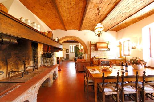 a dining room with a table and a large stone fireplace at Agriturismo Podere Casacce in San Casciano in Val di Pesa