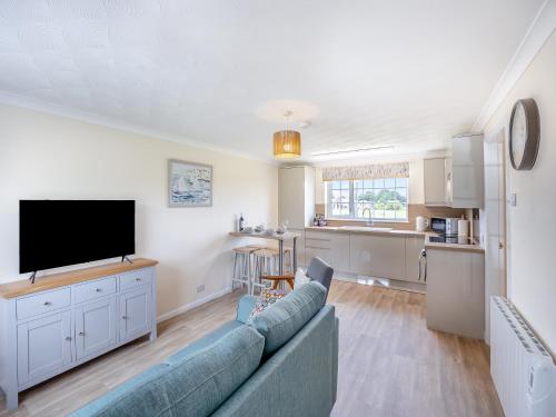 a living room with a couch and a flat screen tv at Oaks - Uk47372 in Burgh le Marsh