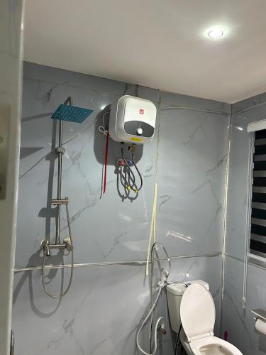 a bathroom with a toilet and a wall with a machine at Stylish Studio Near Jabi Mall in Gwarinpa
