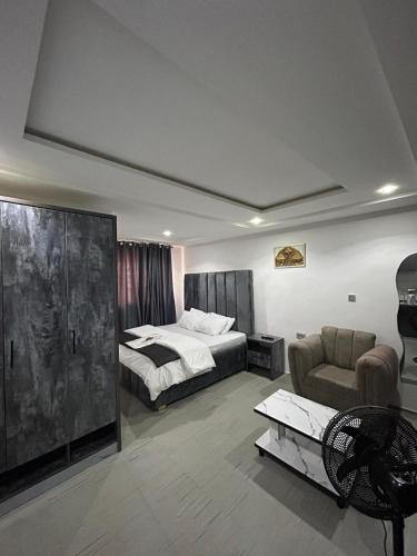 a bedroom with a bed and a couch and a chair at Stylish Studio Near Jabi Mall in Gwarinpa