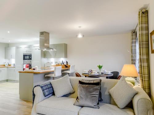a living room with a couch and a kitchen at Popleys in Helmsley