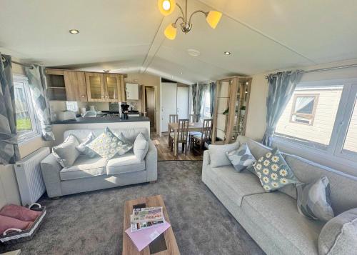 a living room with two couches and a kitchen at Aldbrough Leisure Park in Aldbrough