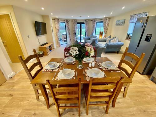 a dining room table and chairs in a living room at Moor Farm Lodge in Bawdeswell