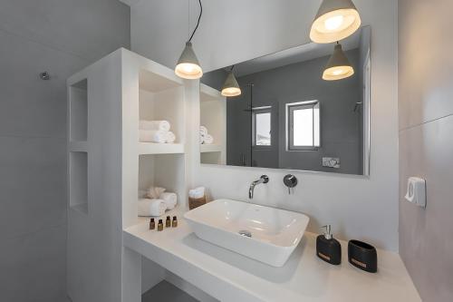a white bathroom with a sink and a mirror at Luxury Complex Ninemia Villas in Faros