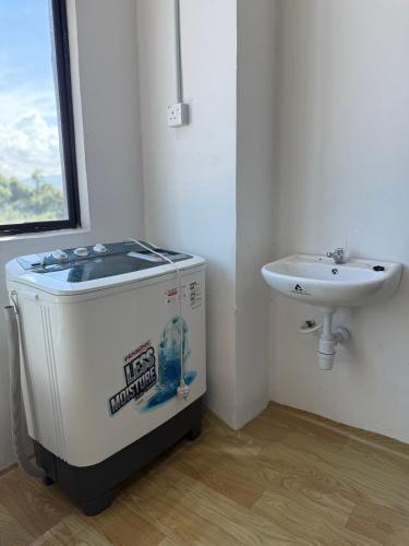 a bathroom with a water heater and a sink at Tido Cottage in Macang