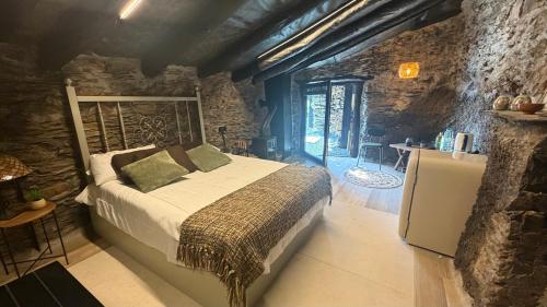 a bedroom with a bed in a stone building at Mourulle in Insúa