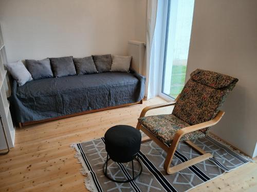 a living room with a couch and a chair at Wein4tel Auszeit in Blumenthal