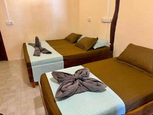 a room with three beds with bows on them at Leaf Villa in Arugam Bay