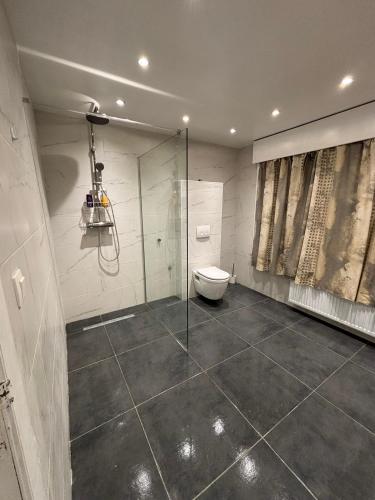 a bathroom with a toilet and a glass shower at The Wandering House in Tremelo