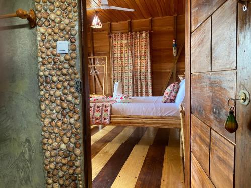 a bedroom with a bed in a wooden cabin at Monte Mar SãoTomé in M. Peixe