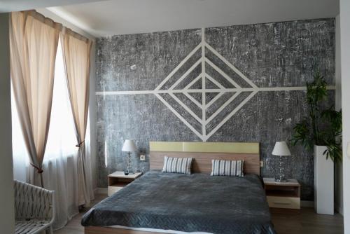 a bedroom with a large bed and a wall at Brio boutique hotel in Velingrad