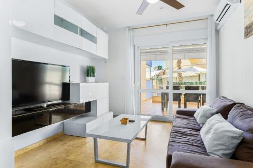 a living room with a couch and a tv and a table at Aguamarina 2 Sunrise in Orihuela