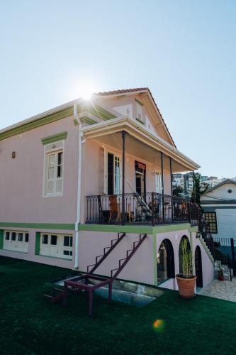 a white house with a balcony and a yard at Casa Om Shanti in Passa Quatro