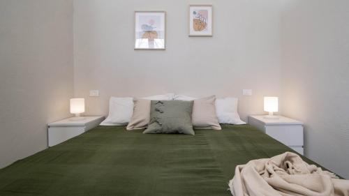 a large bed with two lamps on the sides of it at Casa del Falegname - Loft Rovere con cucina in San Giovanni in Bosco