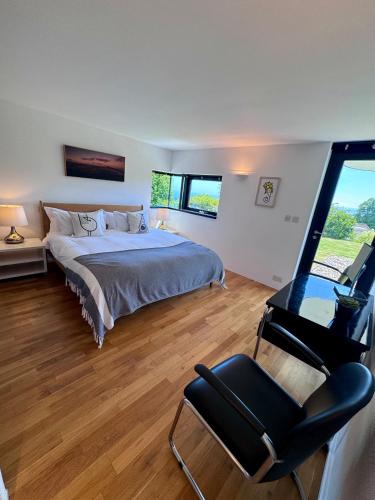 a bedroom with a bed and a chair and a window at The Seahorse Torbay in Torquay