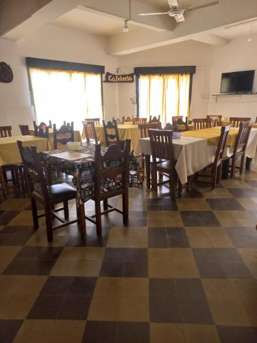a dining room with tables and chairs on a checkered floor at Hotel Praise in Capilla del Monte