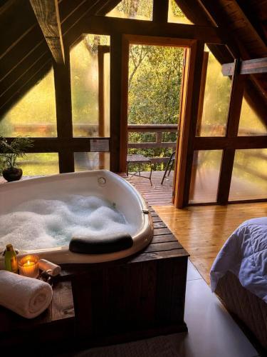 a bath tub sitting in a room with a window at Cabanas dos Plátanos in Gramado