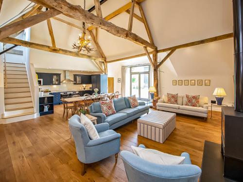 a large living room with wooden floors and wooden beams at Hatchers Barn - Uk42080 in East Garston