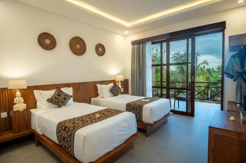 a hotel room with two beds and a balcony at Soulstar Villa Ubud in Ubud