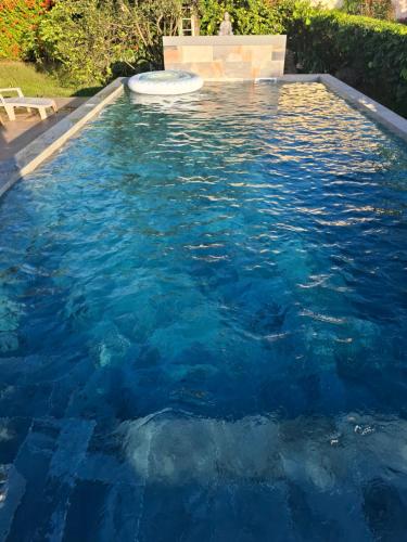 a pool of blue water with a frisbee in it at Appartement dans Villa avec jardin et piscine pour détente et évasion in Montjoly