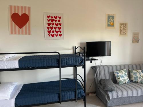 a bedroom with two bunk beds and a couch at Una Piscina sul Mare Apartment in Milazzo