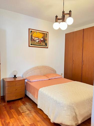 a bedroom with a bed and a dresser and a lamp at Apartma Danijela in Kanal