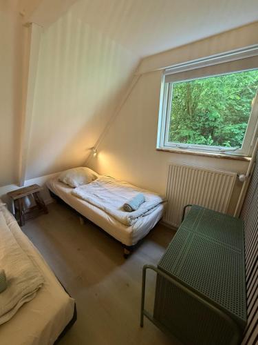 a small room with two beds and a window at Vakantiewoning Asteri's Home in Simpelveld