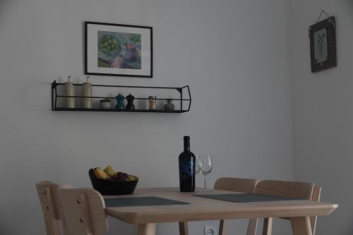 a dining room table with a bottle of wine and a glass at Apartman Mala Artica in Drage