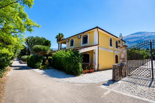 a yellow house with a gate and a fence at Amunì da Vita e Pietro in Carini