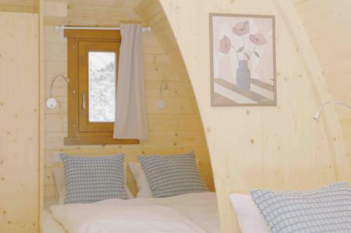 a bedroom with a bed in a log cabin at Traumhafter POD-M mit Seesicht - mit Terrasse aber ohne privates WC in Alpnach