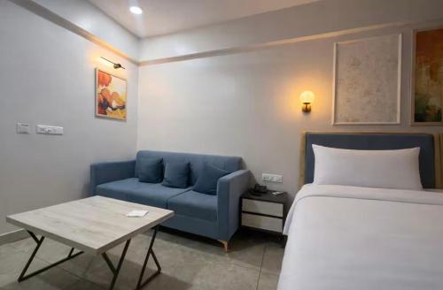 a bedroom with a bed and a blue couch at Belle Vue Stays in Jaipur