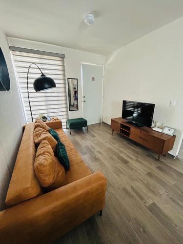 a living room with a couch and a flat screen tv at Camino antiguo a Tesistan in Zapopan