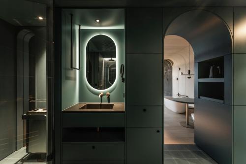 ein Badezimmer mit Waschbecken und Spiegel in der Unterkunft Prinz Rudolf Smart Hotel in Meran