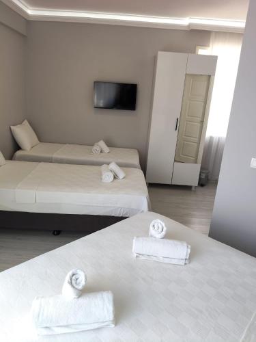 a hotel room with two beds with towels on them at Ayvalık Denizyıldızı Otel in Ayvalık