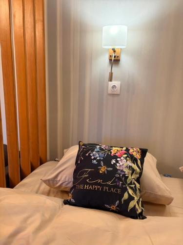 a pillow sitting on top of a bed with a lamp at the HAPPY PLACE in Mykolaiv