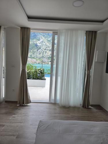 a bedroom with a bed and a large window at Luxury Studio Apartment with Sea View & Heated Pool in Kotor