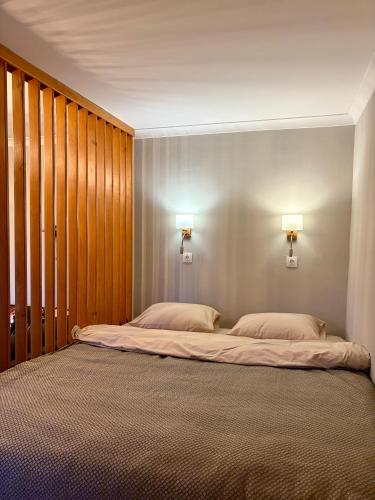 a bedroom with two beds and two lights on the wall at the HAPPY PLACE in Mykolaiv