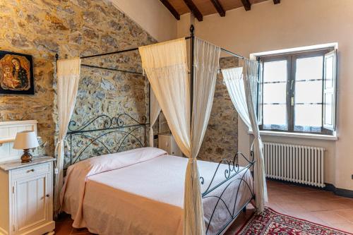 a bedroom with a canopy bed and a window at Agriturismo Morisfarms - Santa Laura in Cura Nuova