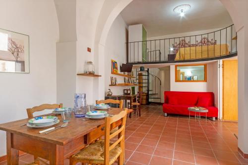 a living room with a table and a red couch at GuestHost - Casa Paola in Cannole