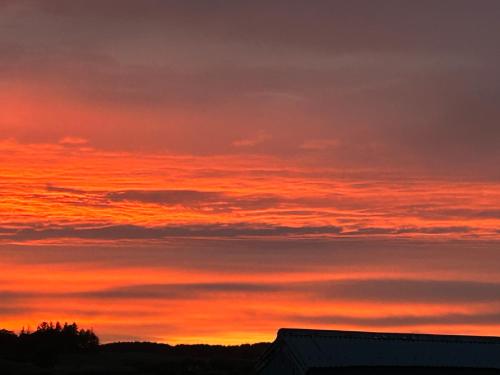 a sunset over the ocean with a red sky at Drumwherry By The Sea in Monreith