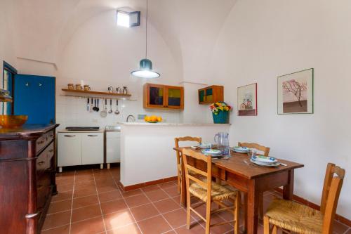a kitchen with a wooden table and a table and chairs at GuestHost - Casa Paola in Cannole