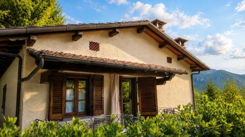 a house with wooden windows and mountains in the background at Villa Marisa in Stazzema