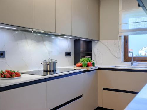 a kitchen with white cabinets and a sink at Holiday Home Sara by Interhome in Tar