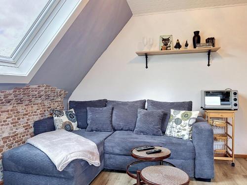 a living room with a blue couch and a brick wall at Apartment Eifelhome One nahe Nürburgring by Interhome in Fuchshofen