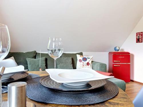 a dining room table with a plate and wine glasses at Apartment Eifelhome Two nahe Nürburgring by Interhome in Fuchshofen