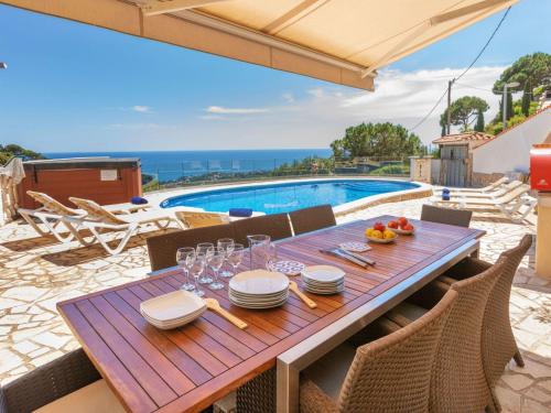 a wooden table with plates and wine glasses on a patio at Holiday Home Floramar by Interhome in Lloret de Mar